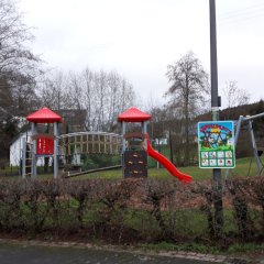 Spielplatz mit modernen Klettergerät, Rutsche und anderen Spielgeräten auf einer Wiese