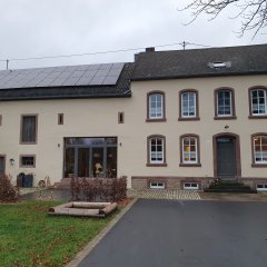 renoviertes Bauernhaus im Eschbach mit Rundbogenfenstern und zu Wohnzwecken umgebaute Scheune