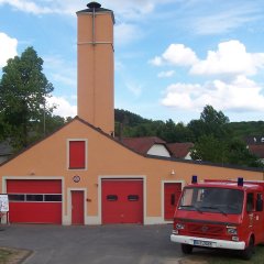 Feuerwehrgerät Bickendorf mit Trockenturm und Feuerwehrauto davor
