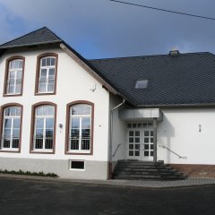 Außenansicht Gemeindehaus mit großen Fenstern am Giebel