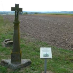 Wegekreuz im Außengelände mit Erläuterungsstele davor