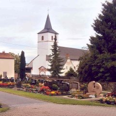 schön gestalteter Friedhof mit Kirche im Hintergrund