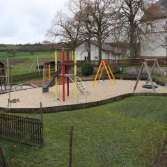 Spielplatz mit großem Sandkasten und modernen Spielgeräten