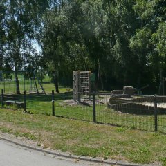 Kinderspielplatz mit Umzäunung und verschiedenen Spielgeräten