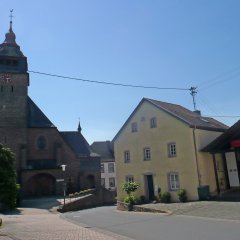 Pfarrkirche in Sandsteinoptik mit angrenzendem Feuerwehrgerätehaus