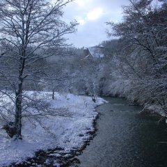 Die Prüm mit schneebedeckter Wiese