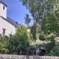 Kirchemit einem Turm am Wasserfall