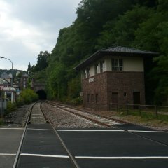 Blick über die Bahngleise in Richtung Eisenbahntunnel in Sandsteinoptik