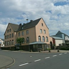 großzügiges Gemeindehaus, dreistöckig mit gläserner Buswartehalle davor