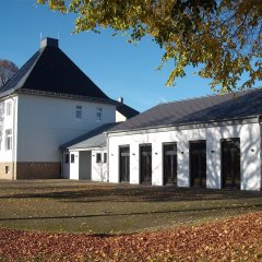 zweistöckiges Gebäude der ehemaligen Schule mit langgezogenem modernem einstöckigen Anbau