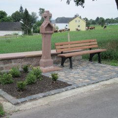 Wegekreuz mit Ruhebank und Blumenbeet