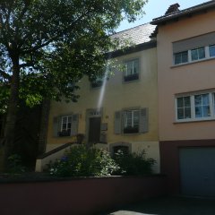 renoviertes Bauernhaus mit Fensterläden aus Holz mit modernerem Anbau