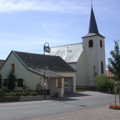 einschiffige Kirche mit Turm und Buswartehalle davor