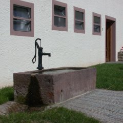 alleinstehender Dorfbrunnen mit Sandsteintrog in Großaufnahme