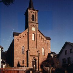 Pfarrkirche mit Turm aus rotem Sandstein in der Frontansicht