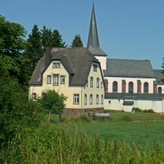 Kirche mit altem Pfarrhaus im Vordergrund