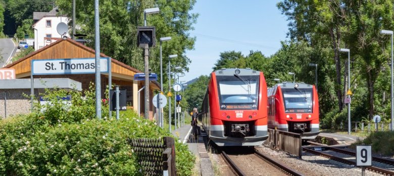 Zwei rote Züge stehen am Bahnhof Sankt Thomas