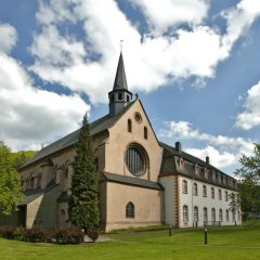 Klosterkiche mit Turm und großem runden Fenster in der Giebelseite