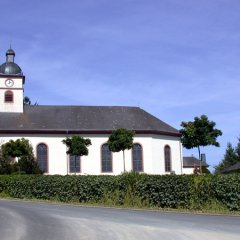 Pfarrkirche in der Seitenansicht mit Glockenturm und Turmuhr