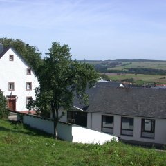 langgestrecktes Jugendheim und danebenstehendes altes dreistöckiges Pfarrhaus