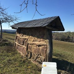 Ein mit Schieferndach versehenes Wildbienenhaus aus Naturmaterialien
