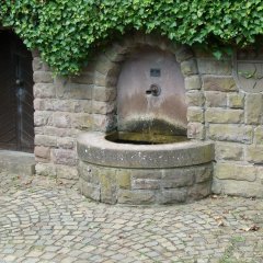 In Sandsteinmauer eingefasste Brunnenanlage