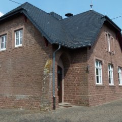 Gemeindehaus in Sandsteinoptik mit modernerem kleinen Anbau am Giebel