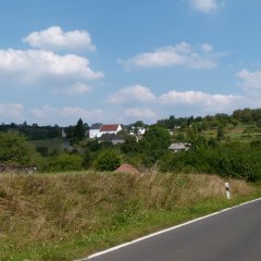 Ortseingang aus der Ferne mit wenigen Häusern